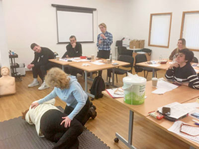 Woman demonstrates first aid in classroom